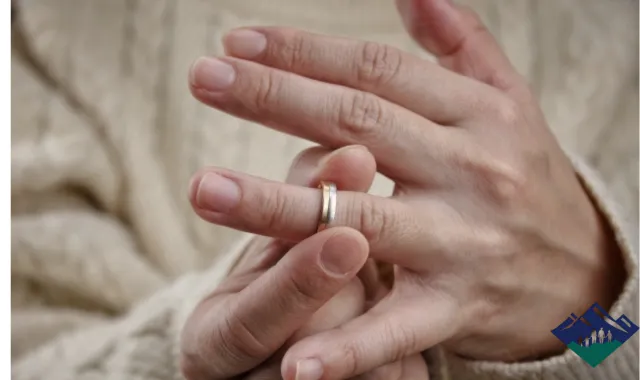 結婚指輪を外そうとする女性の手元