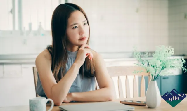 パソコンの前で思案する女性