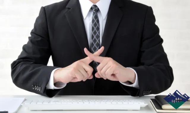 バツ印をつくるスーツの男性