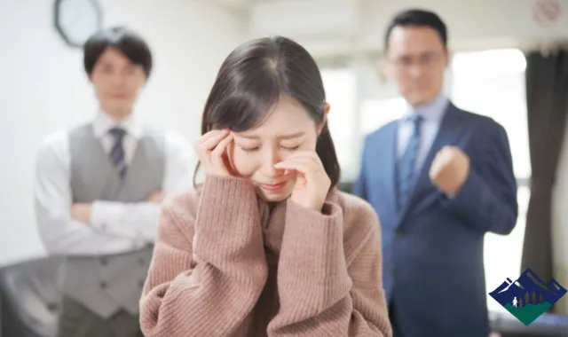 困っている女性と、それを見守るスーツ姿の男性